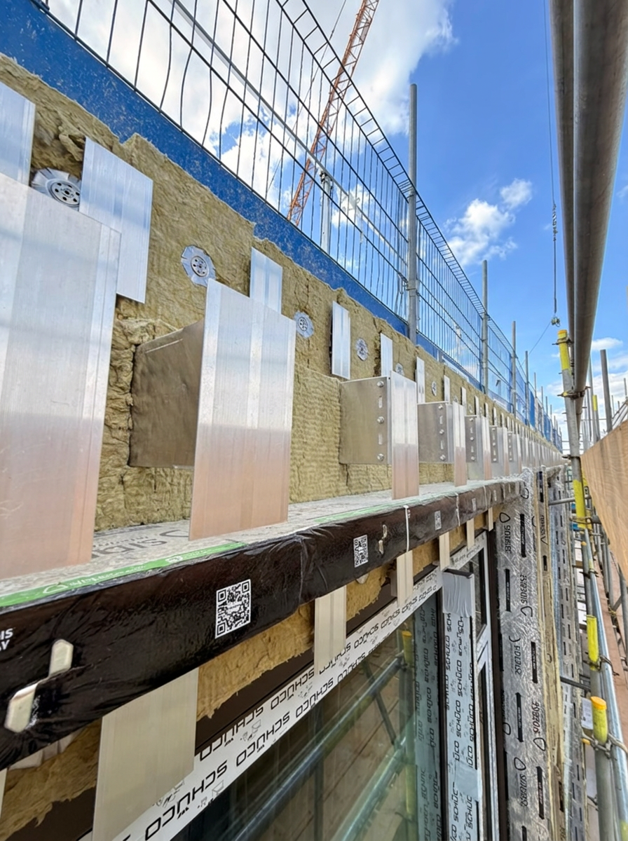 Facade insulation, helping-hand brackets and cavity barrier preparation on a Schüco curtain wall installation