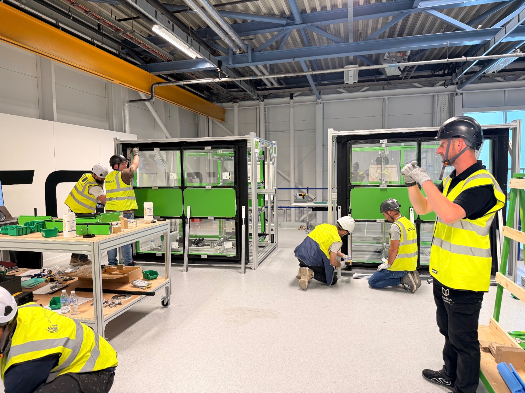 Delta Facades installers working on a Schüco FWS 50 training rig at the Schüco Academy workshop